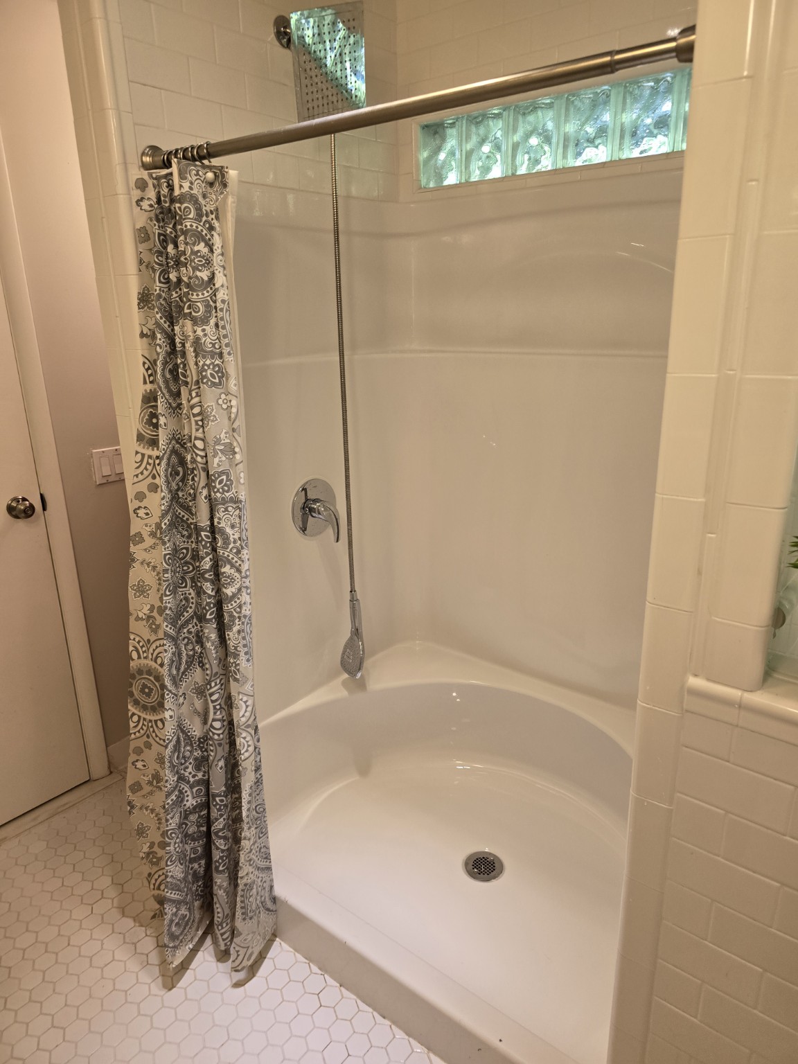 After cleaning: the same shower with a clean white floor and walls