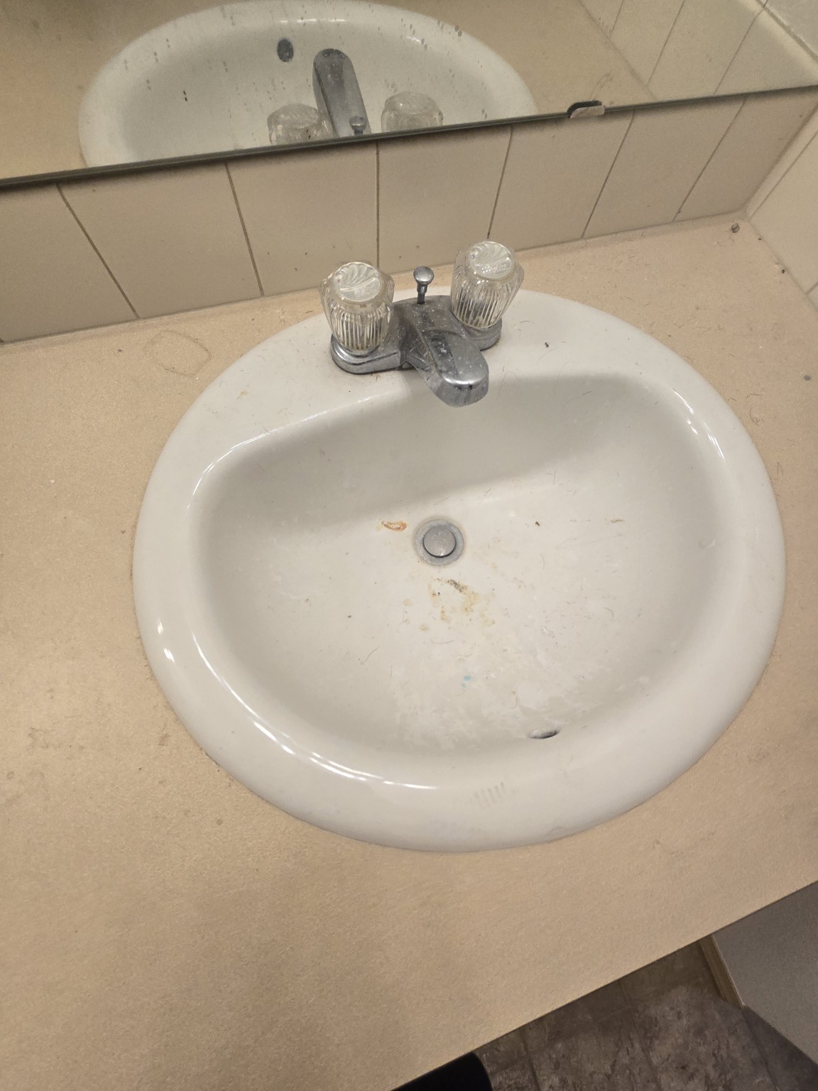 Bathroom sink and faucet with residue before cleaning