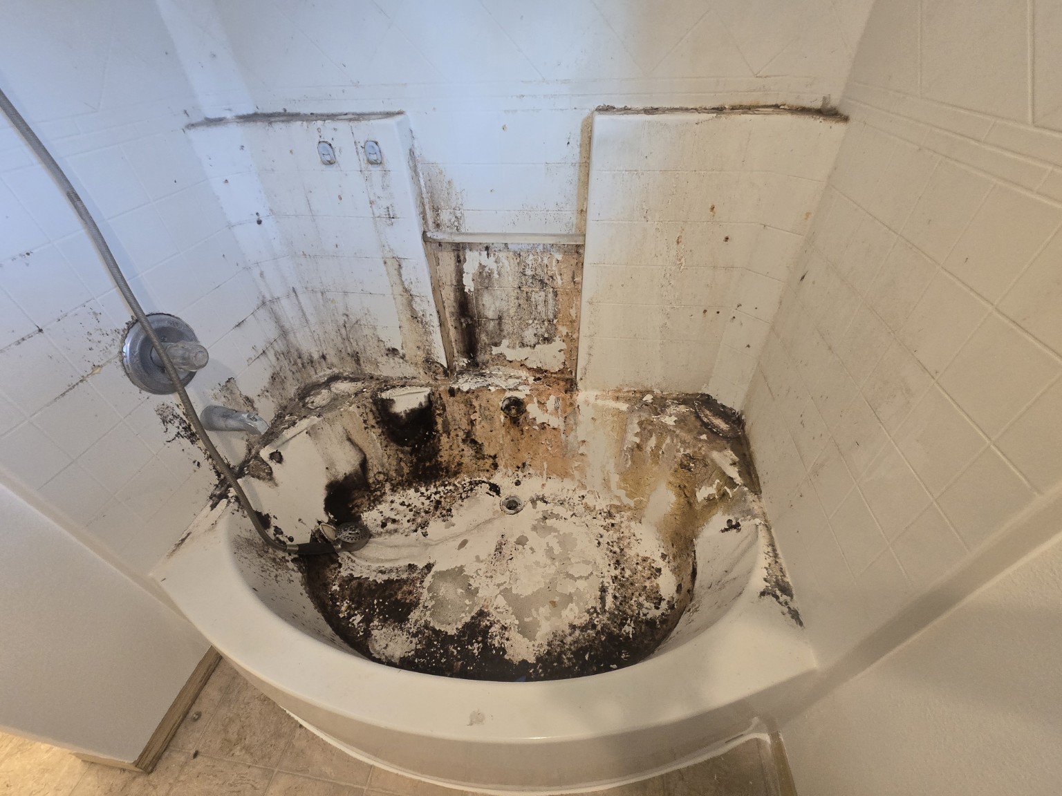 Tub and surround with heavy dark residue before cleaning